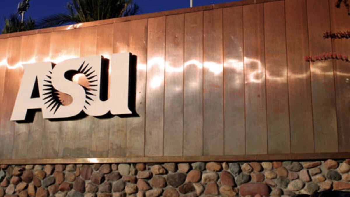 A large copper and stone sign that features the ASU sunburst logo.